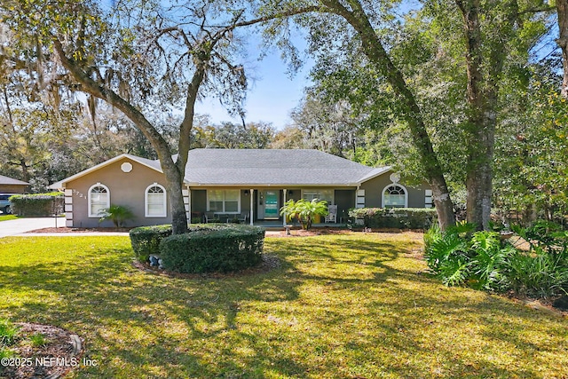 single story home with stucco siding and a front yard