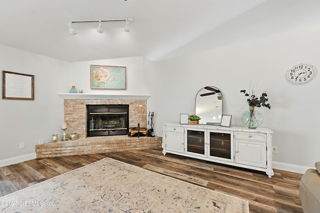 interior space with dark wood-style floors, a fireplace, and baseboards