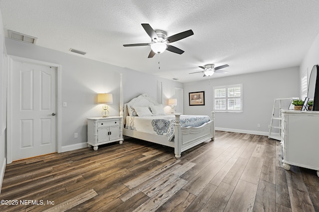 bedroom featuring dark wood-type flooring, visible vents, and a textured ceiling