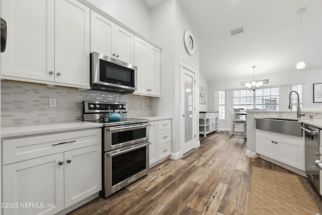 kitchen with a sink, white cabinetry, stainless steel appliances, and backsplash