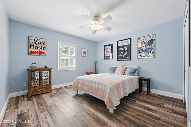 bedroom with dark wood-style floors, a textured ceiling, and baseboards