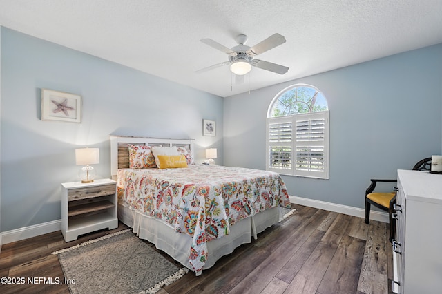 bedroom with dark wood-style floors, ceiling fan, and baseboards