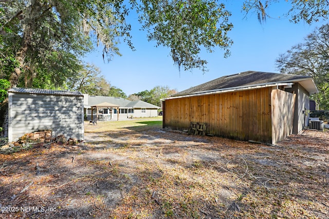 view of yard with central AC unit and an outdoor structure