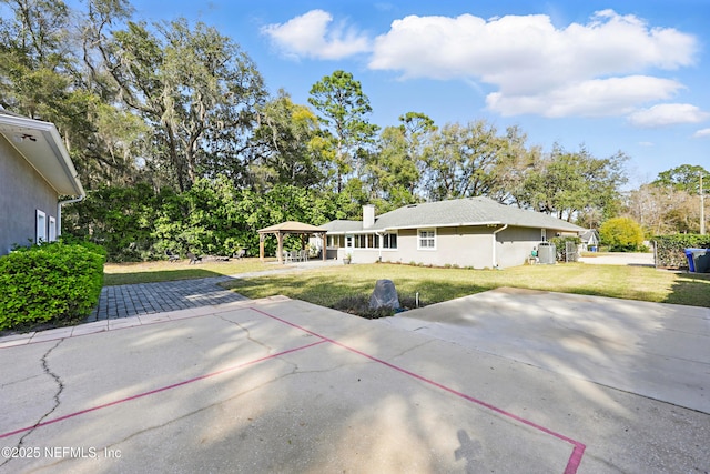 back of house featuring a gazebo, a lawn, a patio area, and stucco siding