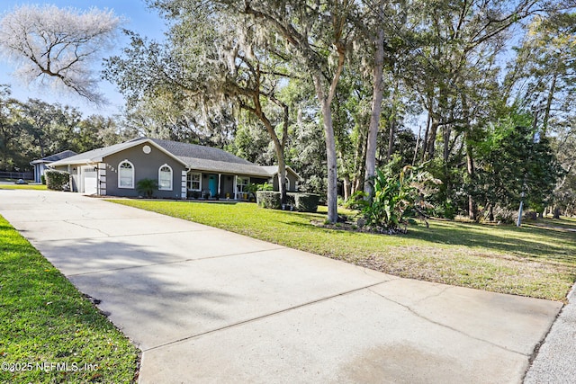 view of front facade with a garage, a front yard, concrete driveway, and stucco siding