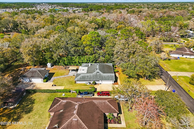 birds eye view of property featuring a forest view