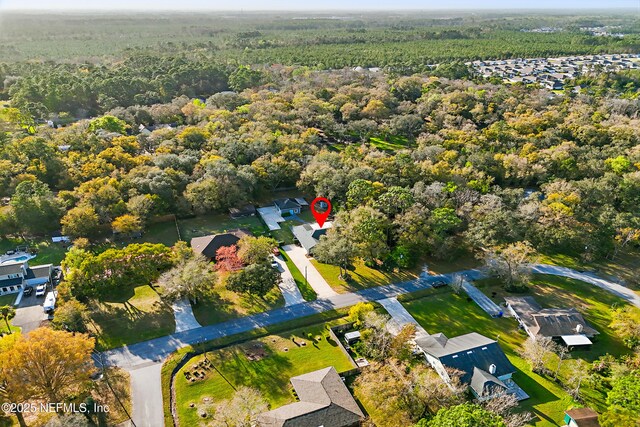 birds eye view of property featuring a forest view and a residential view