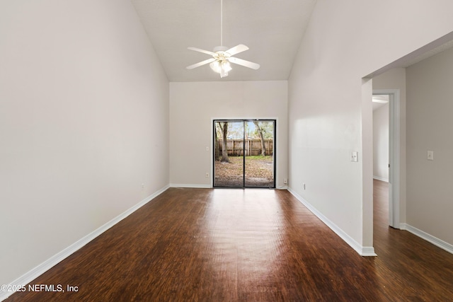 spare room with a ceiling fan, dark wood-style flooring, high vaulted ceiling, and baseboards