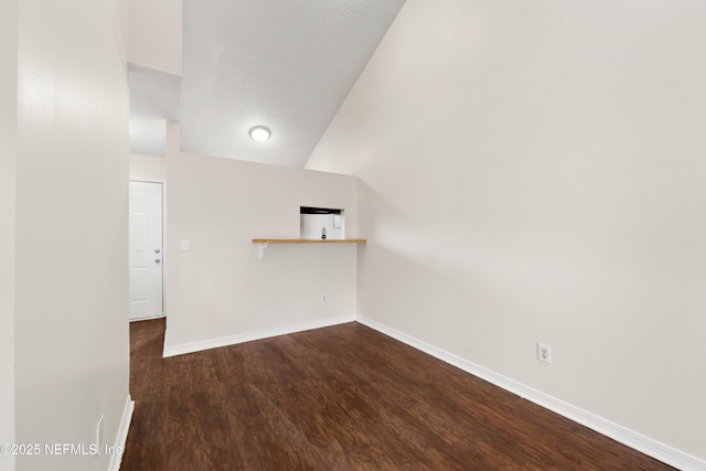 unfurnished room featuring baseboards and dark wood finished floors