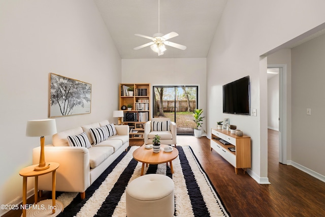 living area with high vaulted ceiling, dark wood-type flooring, a ceiling fan, and baseboards