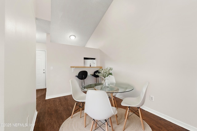 dining area with baseboards and wood finished floors