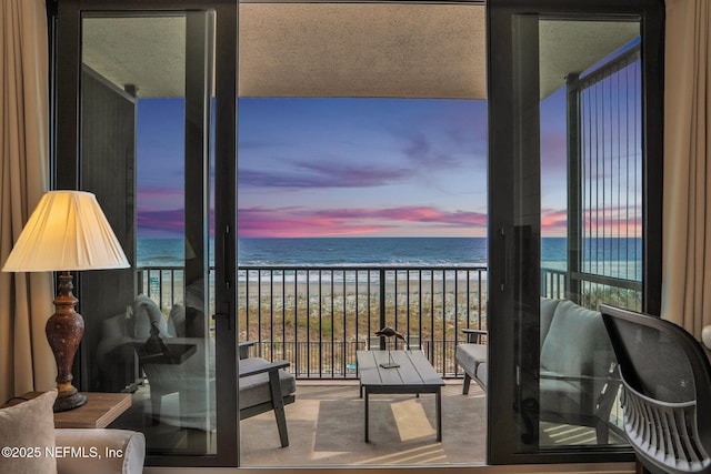 balcony with a water view and a view of the beach