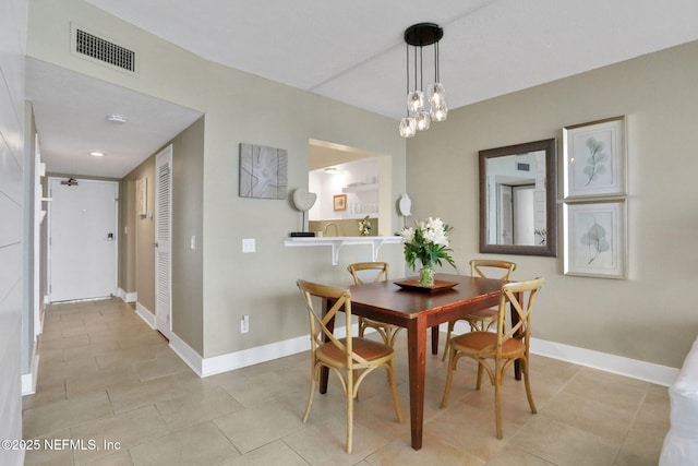 dining room featuring light tile patterned floors, baseboards, visible vents, and a notable chandelier