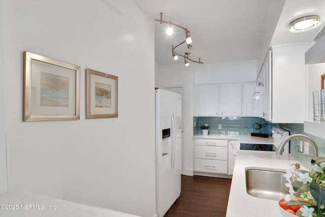 kitchen with stove, a sink, light countertops, white fridge with ice dispenser, and tasteful backsplash