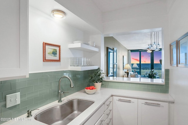 kitchen with light countertops, tasteful backsplash, and white cabinets