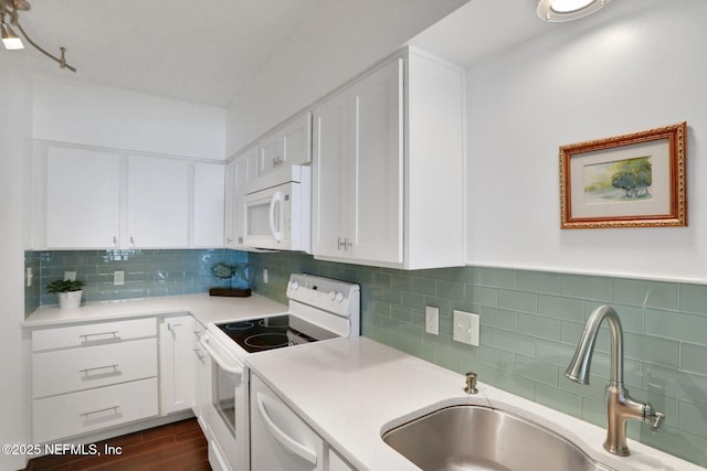 kitchen with light countertops, dark wood-type flooring, white cabinetry, a sink, and white appliances