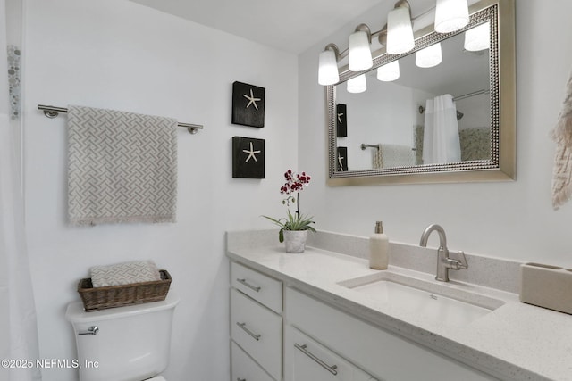 bathroom featuring curtained shower, vanity, and toilet