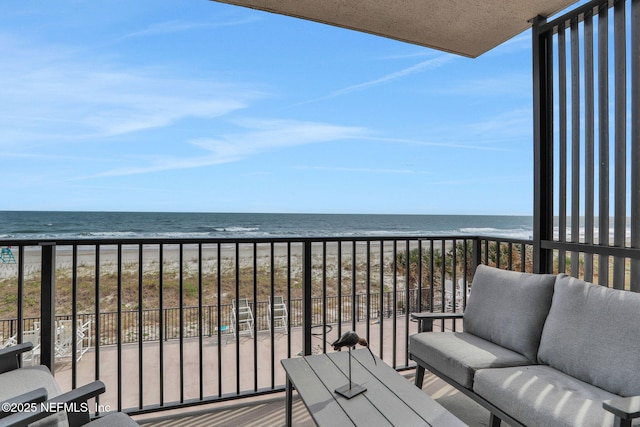 balcony with a water view, a beach view, and an outdoor living space