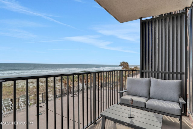 balcony featuring a water view and a view of the beach