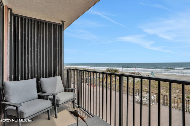 balcony featuring a beach view and a water view