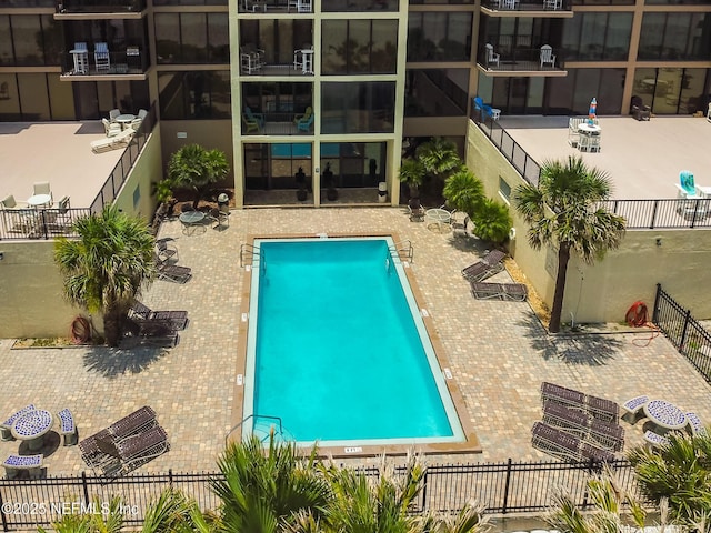 community pool with fence private yard and a patio area