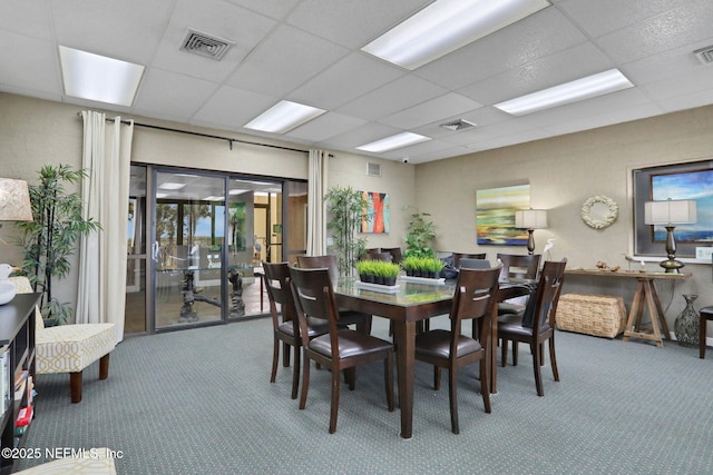 dining area featuring a paneled ceiling, visible vents, and carpet flooring