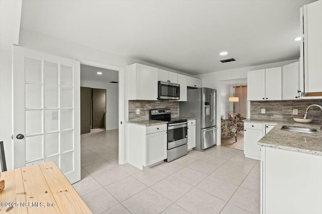 2204 Chablis Ct W, Orange Park, FL 32073 - kitchen featuring visible vents, white cabinets, stainless steel appliances, a sink, and light tile patterned flooring