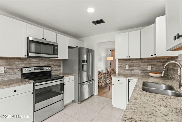 kitchen with visible vents, appliances with stainless steel finishes, white cabinetry, a sink, and light tile patterned flooring