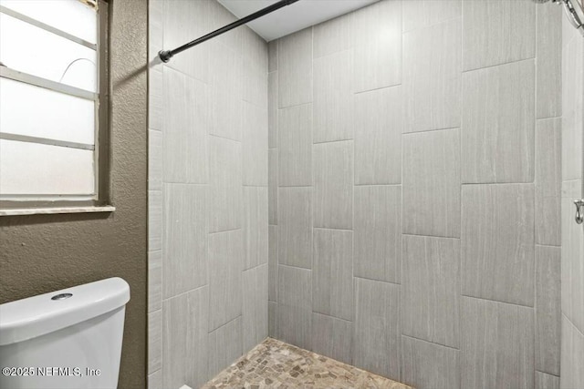 2204 Chablis Ct W, Orange Park, FL 32073 - bathroom featuring a textured wall, a tile shower, and toilet