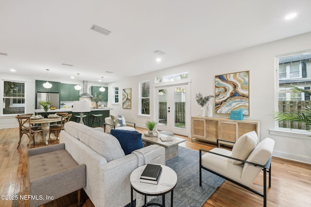 living room featuring recessed lighting, visible vents, light wood-style flooring, and french doors