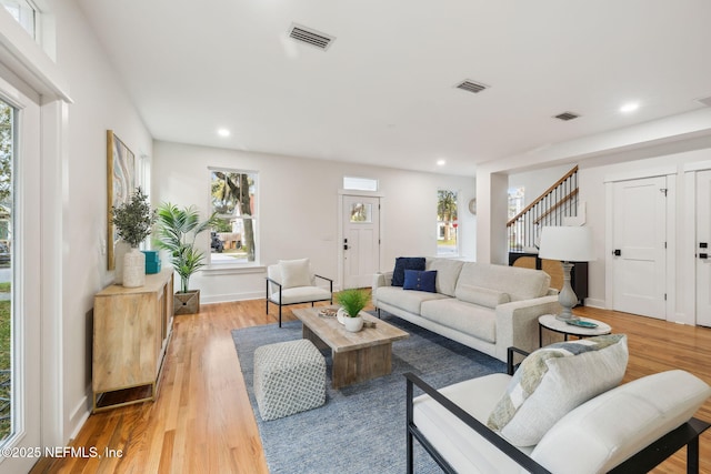 living room with stairway, recessed lighting, visible vents, and light wood-type flooring