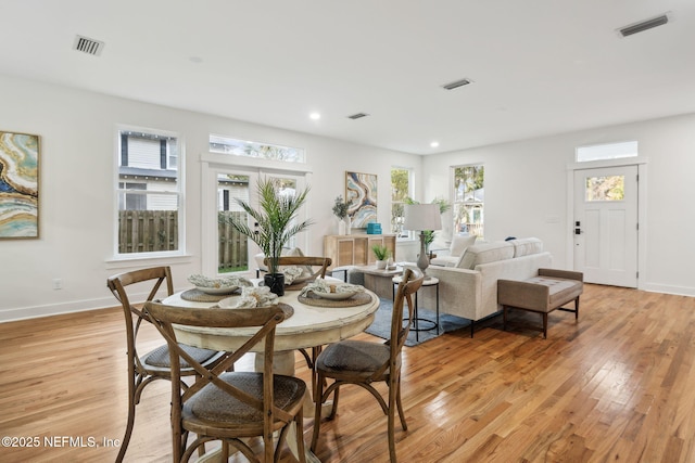 dining space featuring light wood finished floors, visible vents, and baseboards