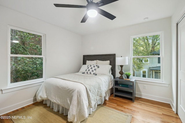 bedroom with baseboards, wood finished floors, and a ceiling fan