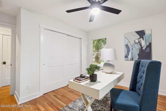 home office with baseboards, light wood-style flooring, and a ceiling fan