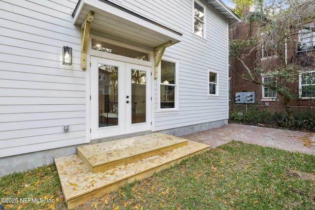 entrance to property featuring a patio area, french doors, and fence