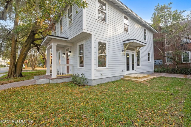 view of front of home featuring a porch, french doors, and a front yard