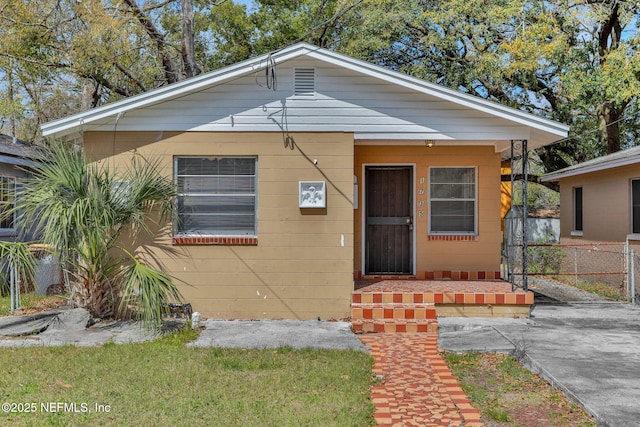 bungalow-style house with fence