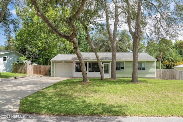 ranch-style home with driveway, an attached garage, fence, and a front yard