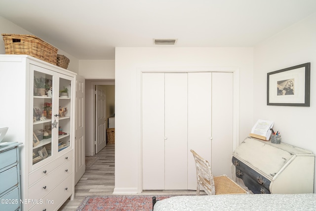 bedroom featuring light wood-style flooring, a closet, and visible vents