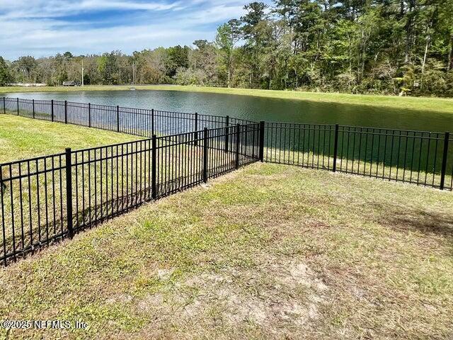 view of yard with a water view and a fenced backyard