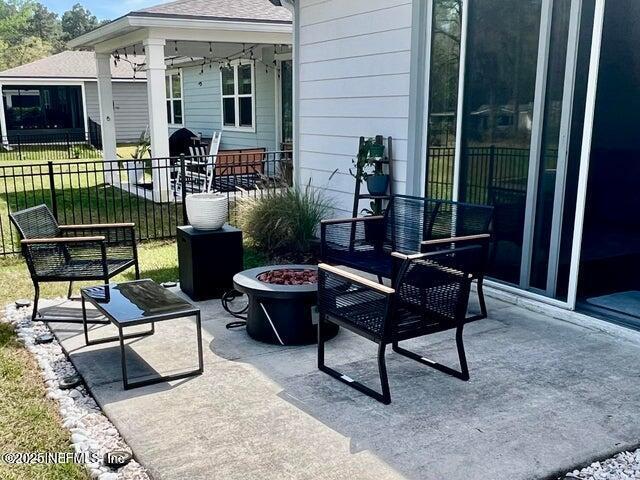 view of patio featuring an outdoor fire pit and fence