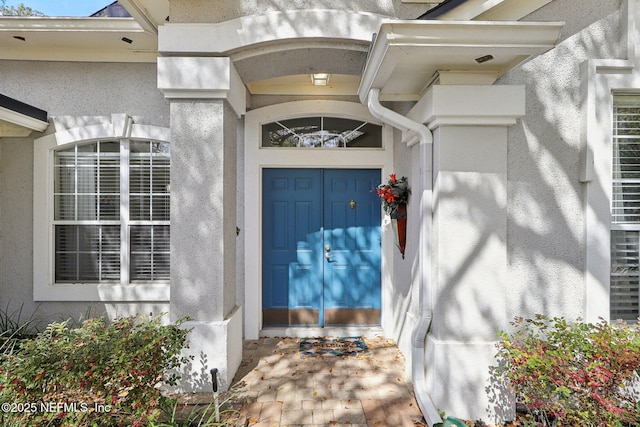 view of exterior entry with stucco siding