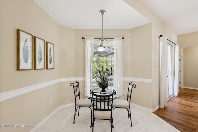 tiled dining area with arched walkways and baseboards