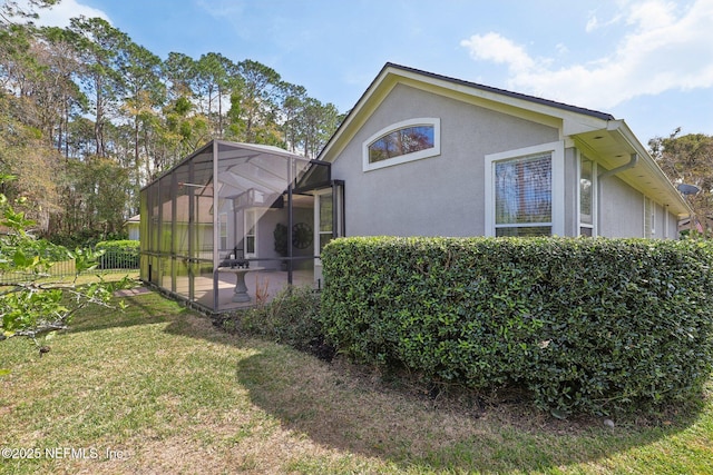 view of property exterior with a lawn, a lanai, fence, a patio area, and stucco siding