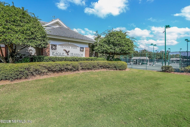 surrounding community with fence and a yard