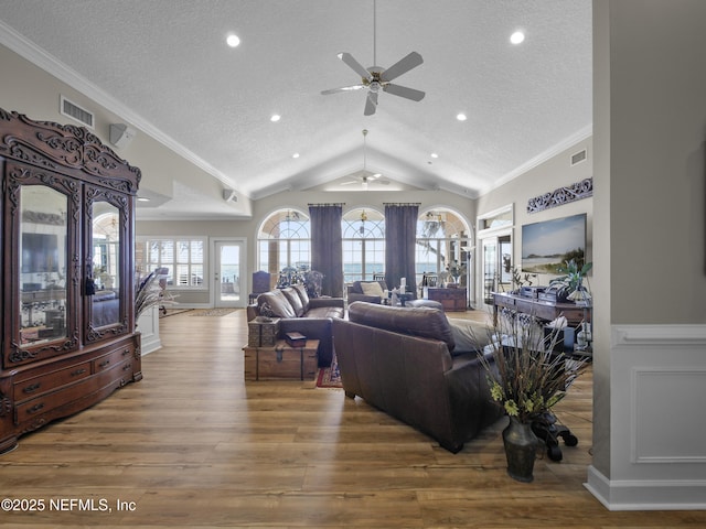 living room featuring wood finished floors, ceiling fan, vaulted ceiling, and ornamental molding