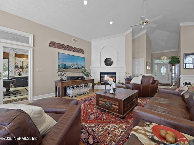 living room featuring ornamental molding, a fireplace, visible vents, and ceiling fan