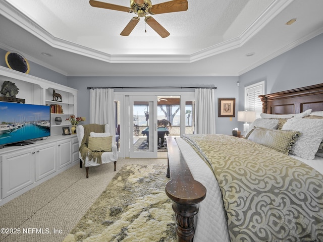 bedroom with ornamental molding, a textured ceiling, a raised ceiling, access to outside, and carpet flooring