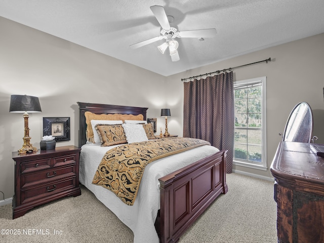 bedroom with light carpet, baseboards, a textured ceiling, and a ceiling fan