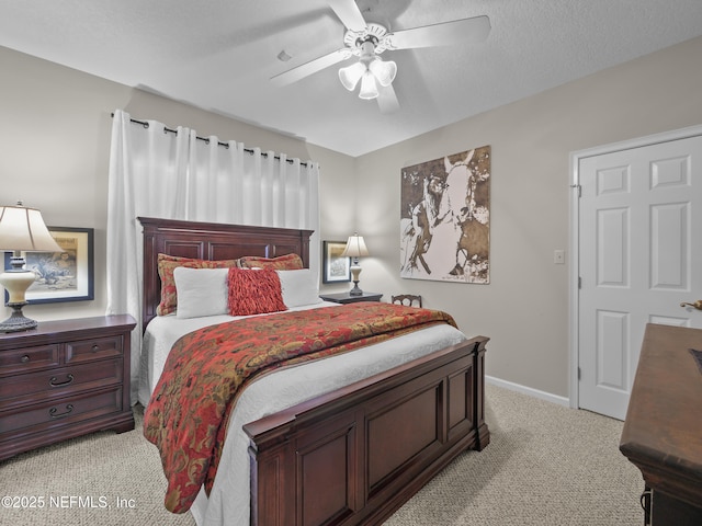 bedroom featuring light colored carpet, a textured ceiling, a ceiling fan, and baseboards